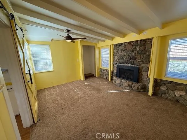a view of empty room with fireplace and windows