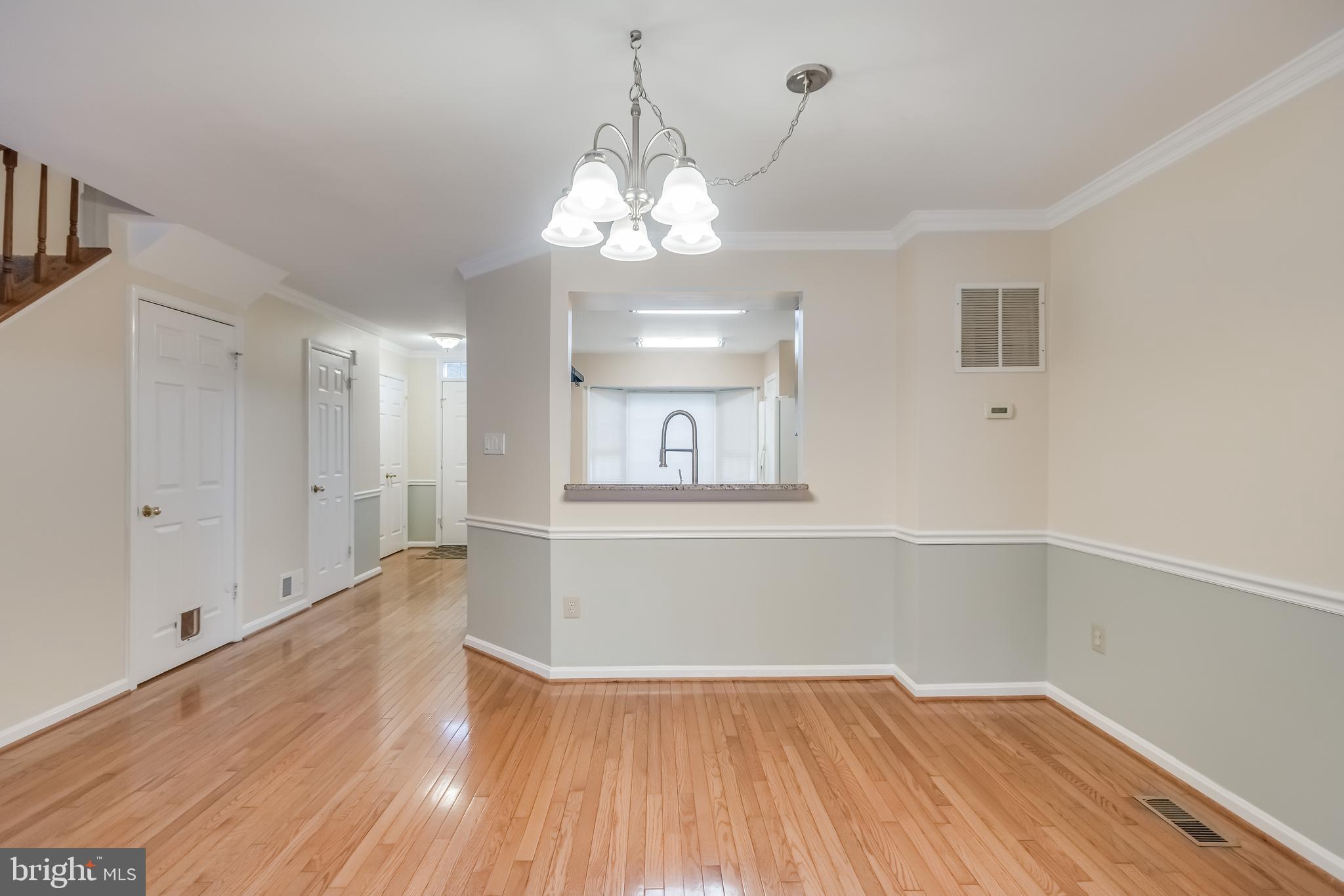 8735 Stone Hill Place Springfield, VA 22153 - Photo 21 of 51 a view of a room with wooden floor and chandelier