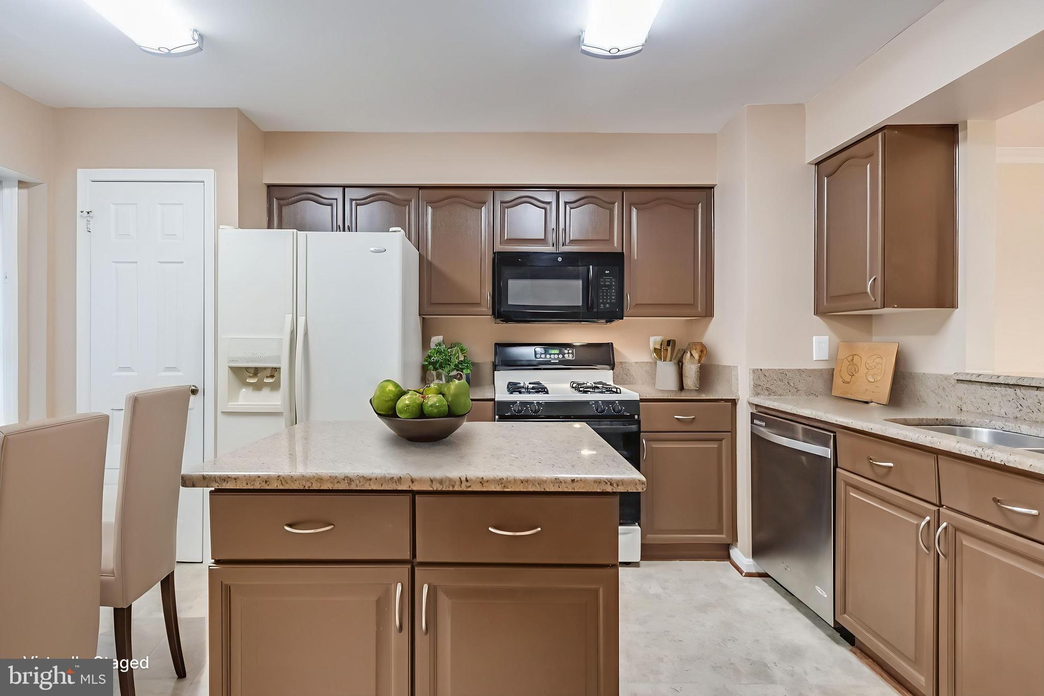 8735 Stone Hill Place Springfield, VA 22153 - Photo 3 of 51 a kitchen with stainless steel appliances kitchen island granite countertop a refrigerator and a sink