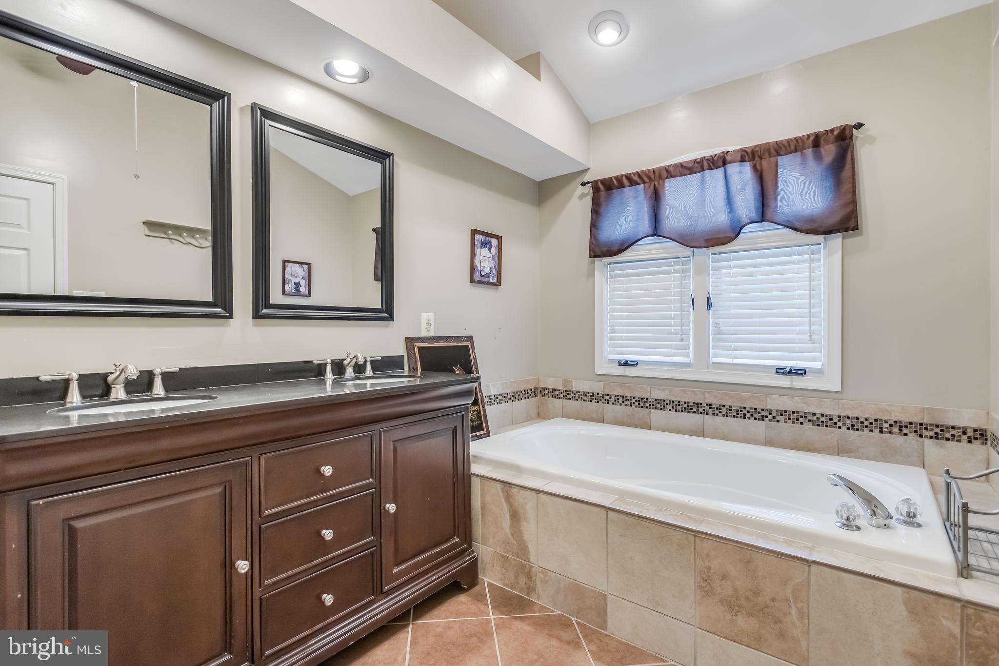 8735 Stone Hill Place Springfield, VA 22153 - Photo 33 of 51 a spacious bathroom with a granite countertop sink and a bathtub