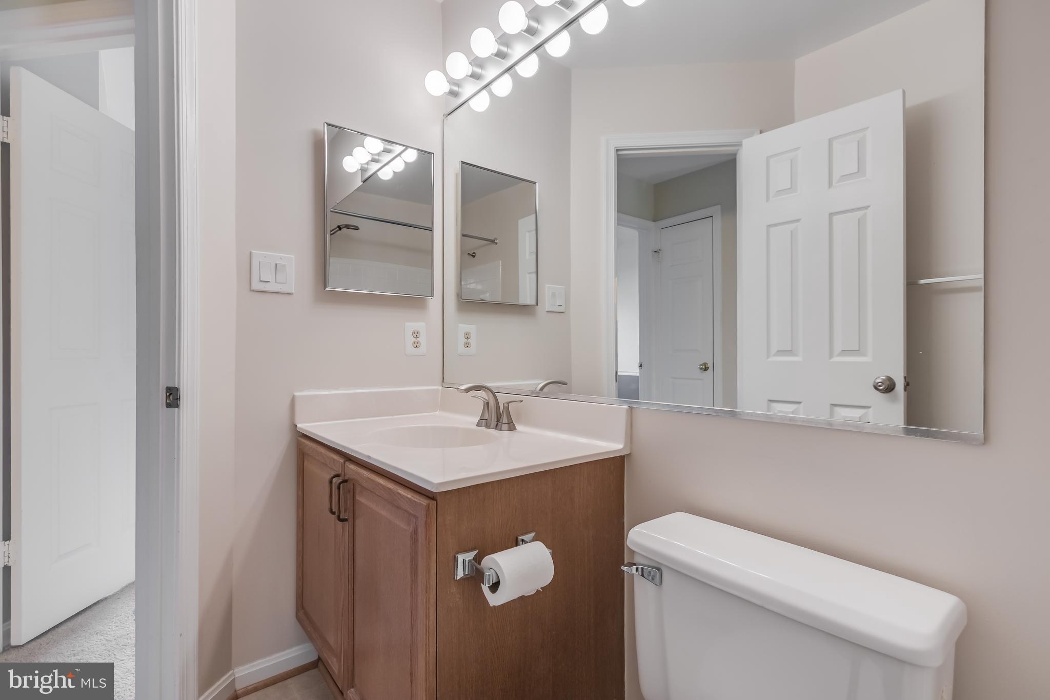 8735 Stone Hill Place Springfield, VA 22153 - Photo 41 of 51 a bathroom with a toilet a sink and mirror