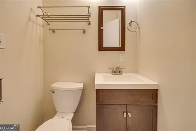 a bathroom with a toilet sink and mirror