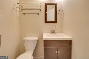 a bathroom with a toilet sink and mirror
