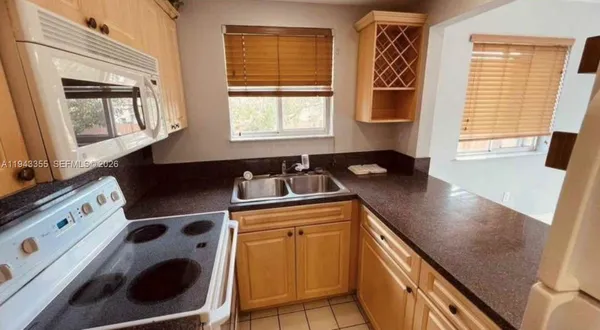 a kitchen with a sink a stove and a microwave