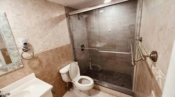 a bathroom with a granite countertop toilet a sink and a shower