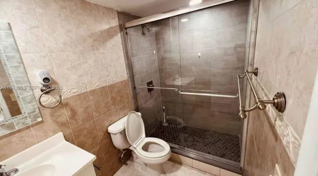 a bathroom with a granite countertop toilet a sink and a shower