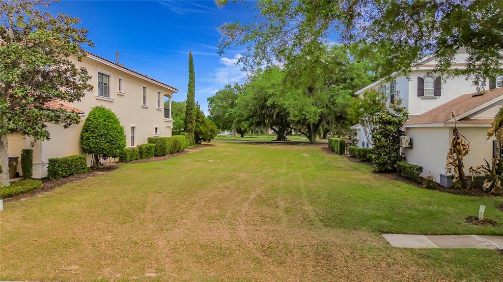 a view of a house with a yard and basketball court