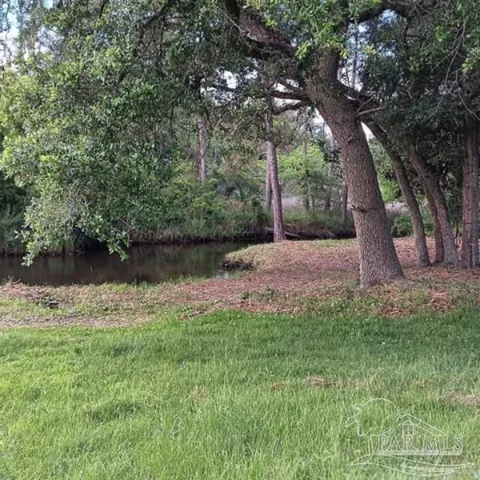 a backyard of a house with lots of green space and lake view