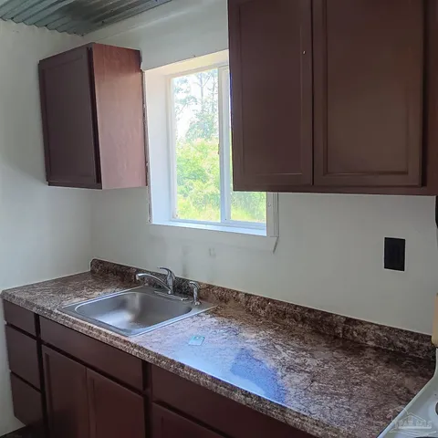 a kitchen with a sink cabinets and a window