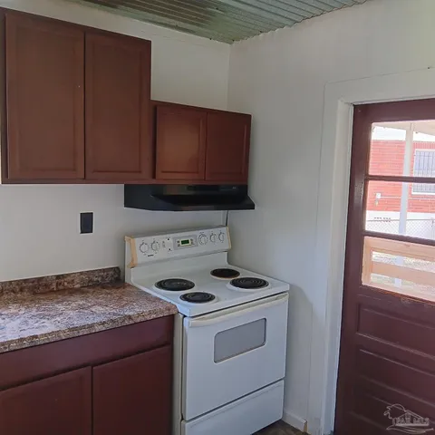 a kitchen with granite countertop cabinets washer and dryer