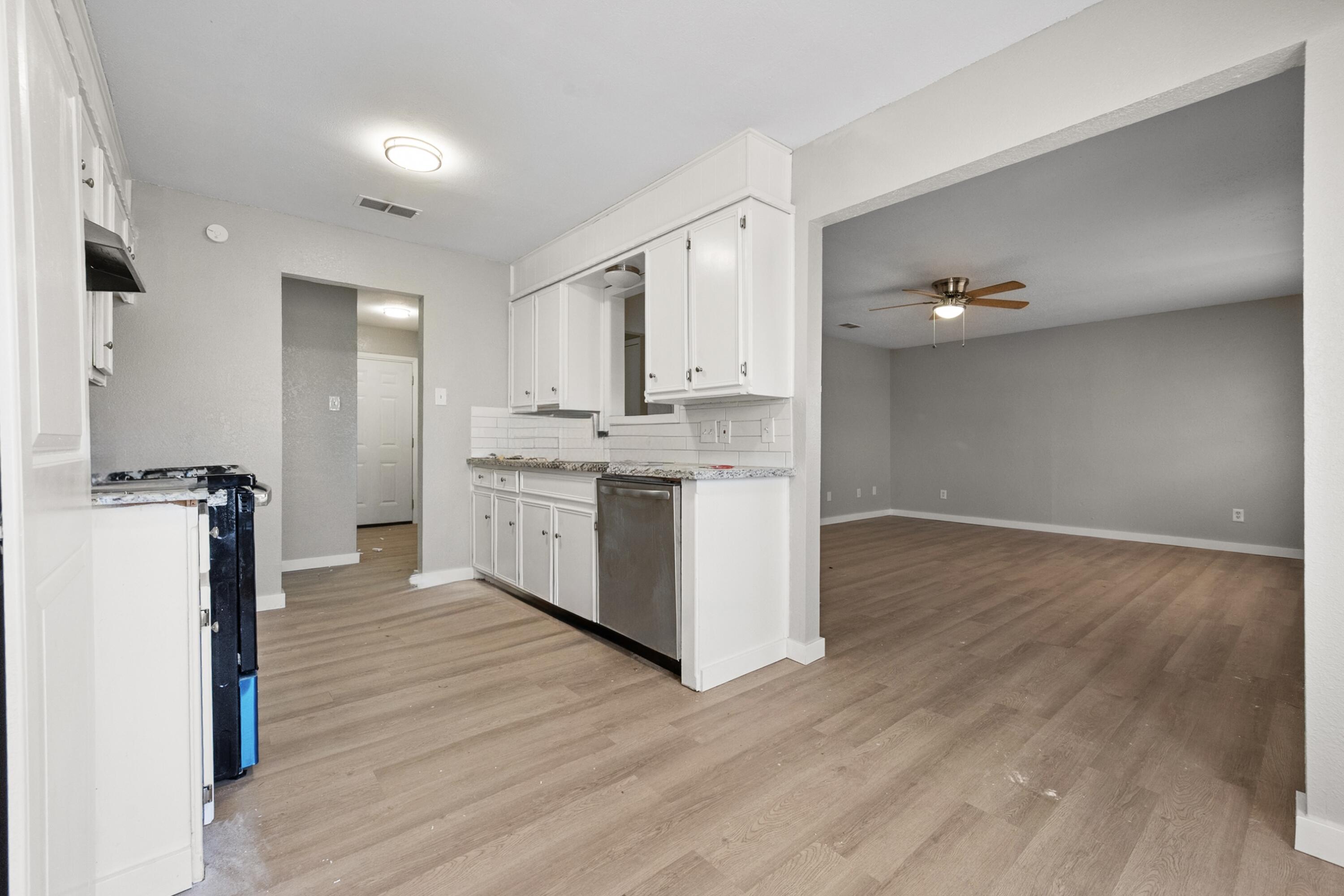 8110 Uvalde Avenue Lubbock, TX 79423 - Photo 4 of 11 a kitchen with a stove a refrigerator and a hard wood floor