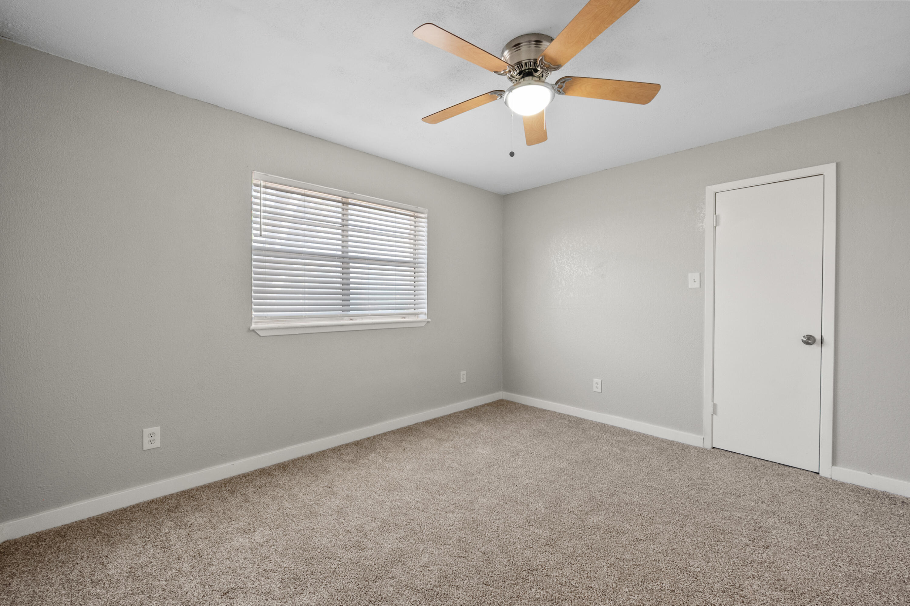 8110 Uvalde Avenue Lubbock, TX 79423 - Photo 6 of 11 an empty room with a window and a fan