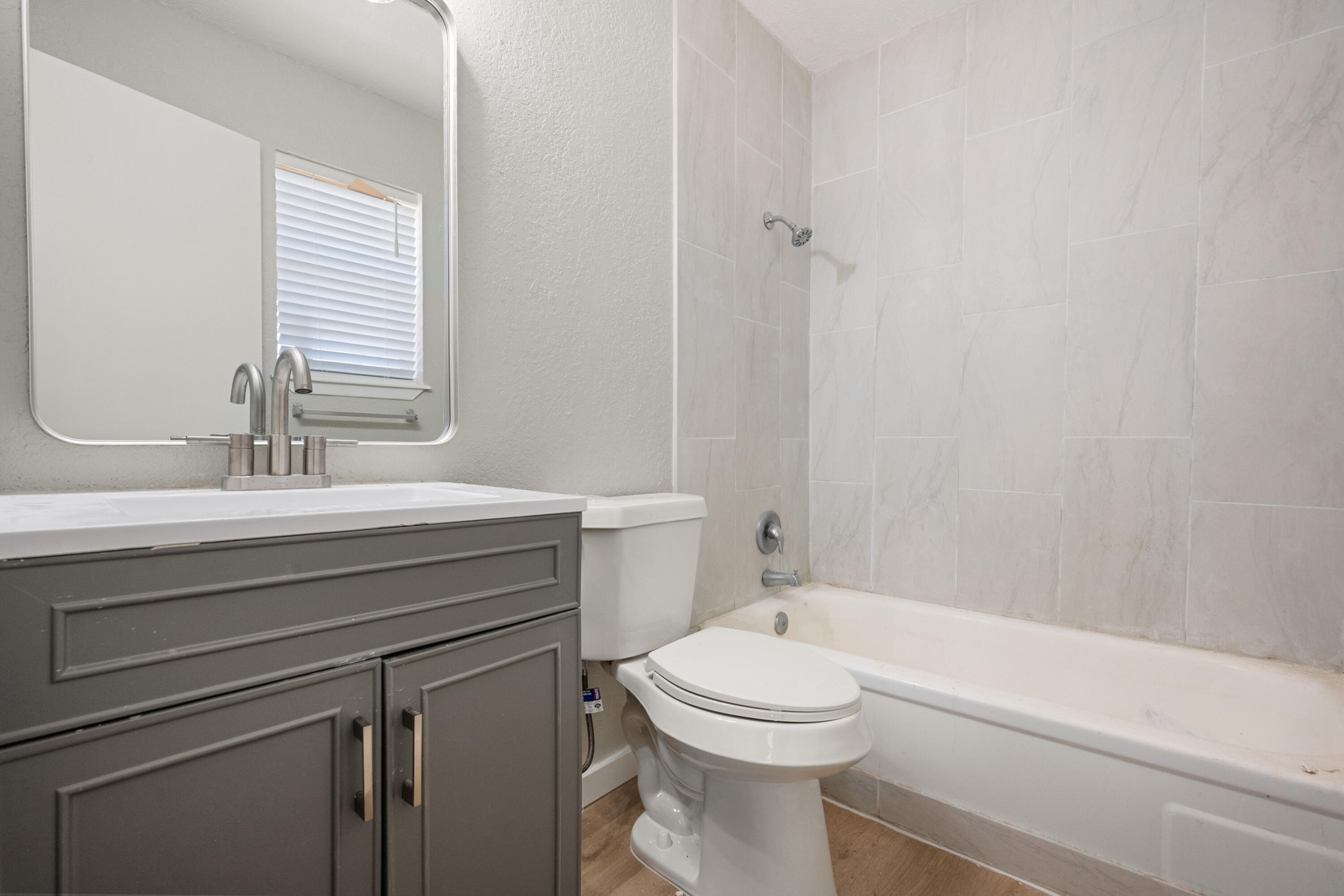 8110 Uvalde Avenue Lubbock, TX 79423 - Photo 8 of 11 a bathroom with a sink a toilet and shower