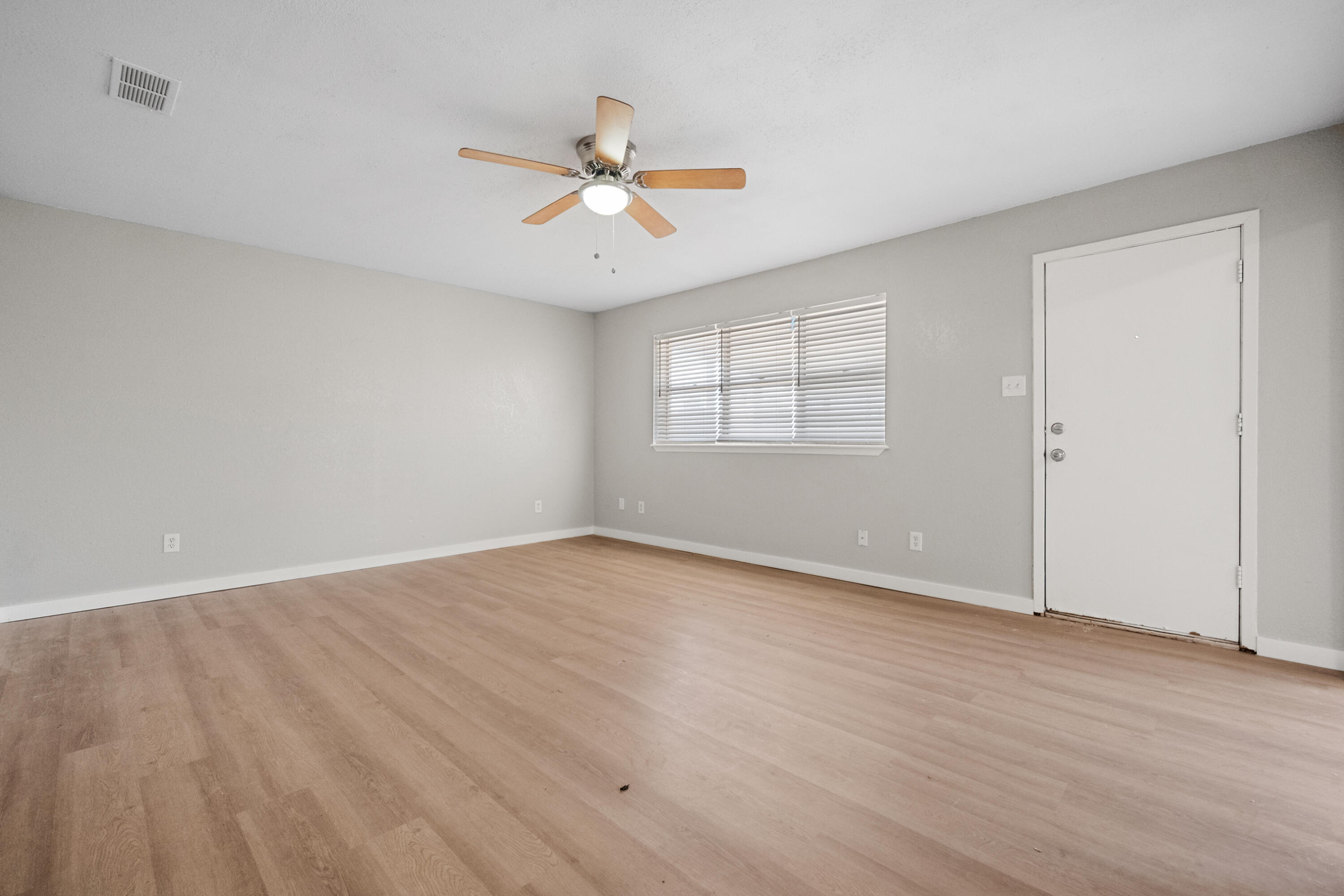 8110 Uvalde Avenue Lubbock, TX 79423 - Photo 9 of 11 an empty room with wooden floor fan and windows