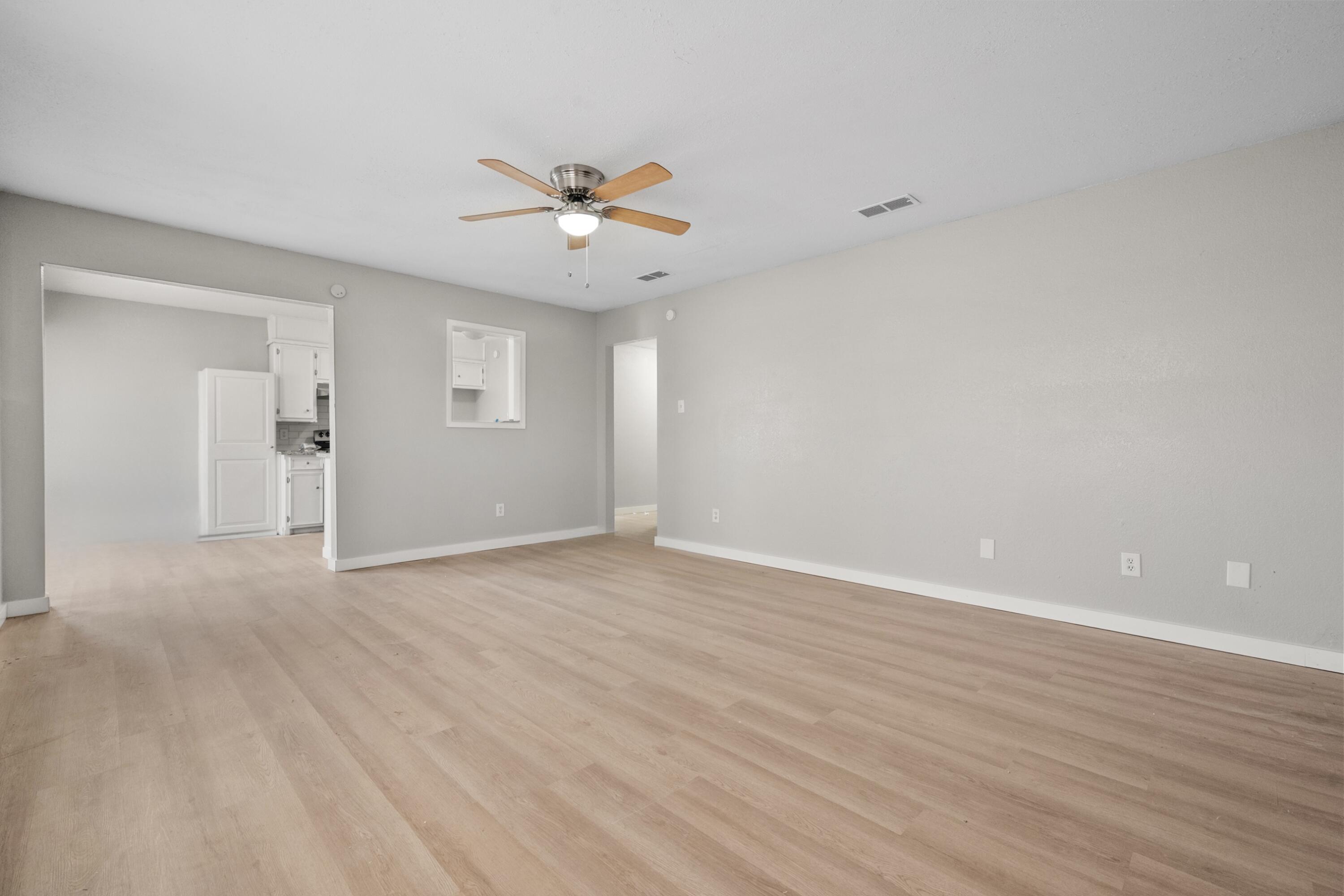 8110 Uvalde Avenue Lubbock, TX 79423 - Photo 10 of 11 a view of an empty room with wooden floor and a ceiling fan
