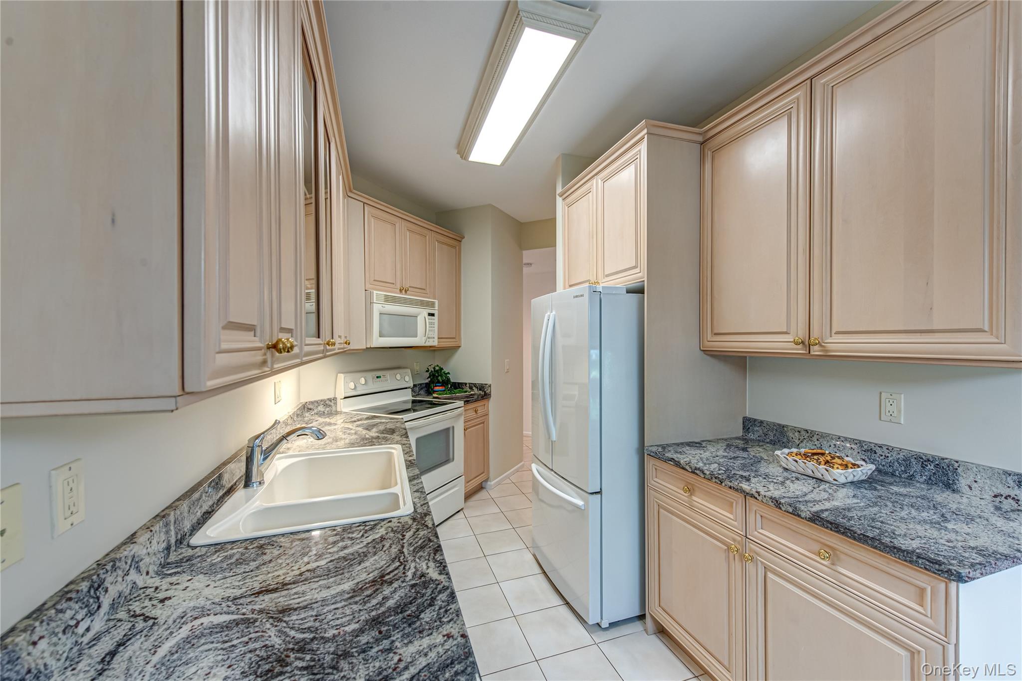 93 Carriage Lane, Unit AVON LOWER Plainview, NY 11803 - Photo 13 of 36 a kitchen with stainless steel appliances granite countertop a refrigerator sink and stove