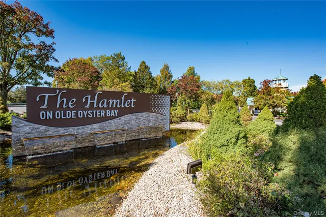a view of a sign board with large trees