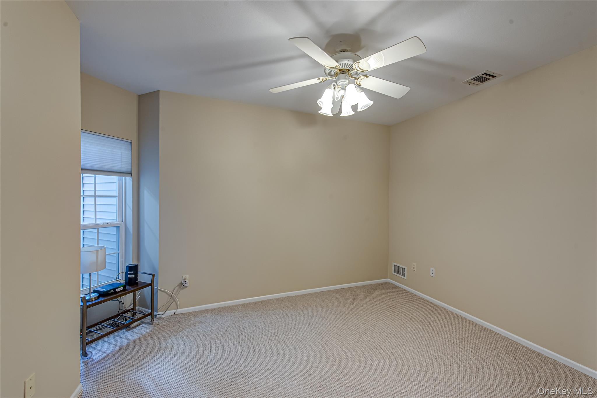 93 Carriage Lane, Unit AVON LOWER Plainview, NY 11803 - Photo 21 of 36 an empty room with windows and fan