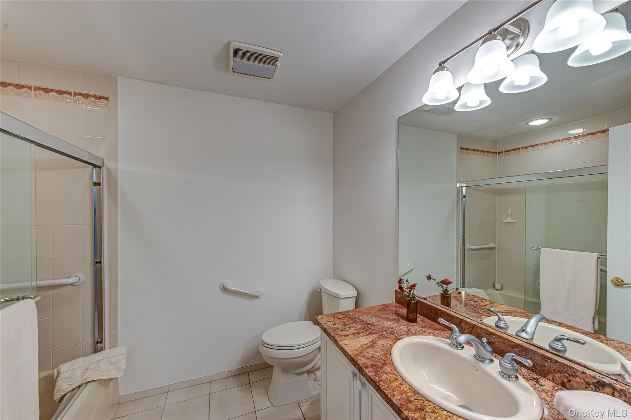 93 Carriage Lane, Unit AVON LOWER Plainview, NY 11803 - Photo 22 of 36 a bathroom with a sink a toilet a mirror and shower