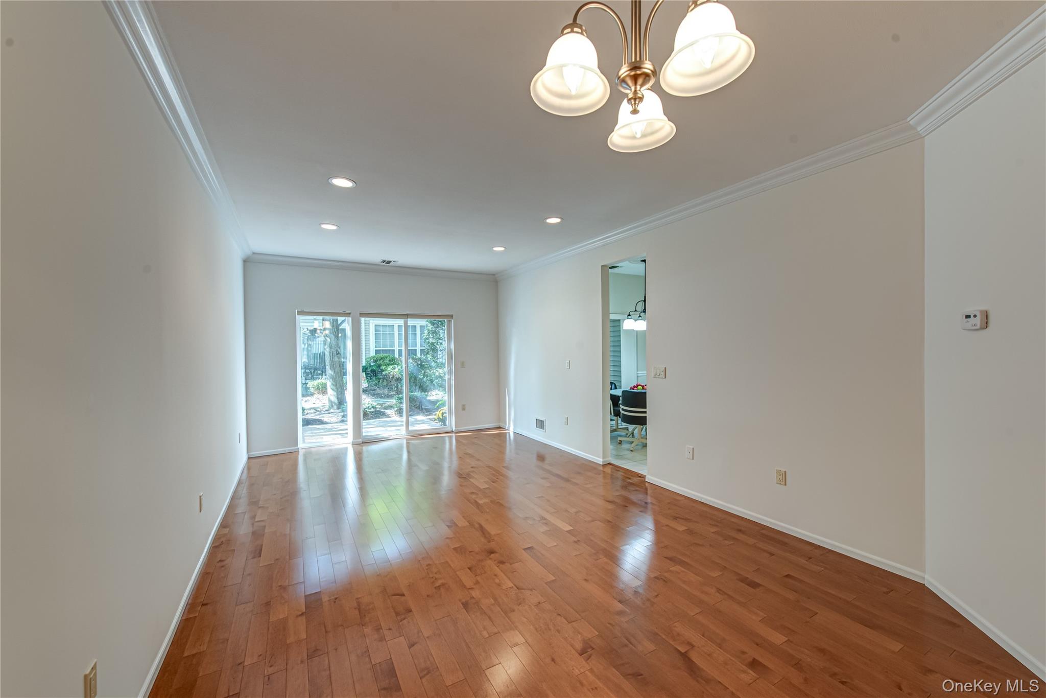 93 Carriage Lane, Unit AVON LOWER Plainview, NY 11803 - Photo 9 of 36 a view of an empty room with wooden floor and a window