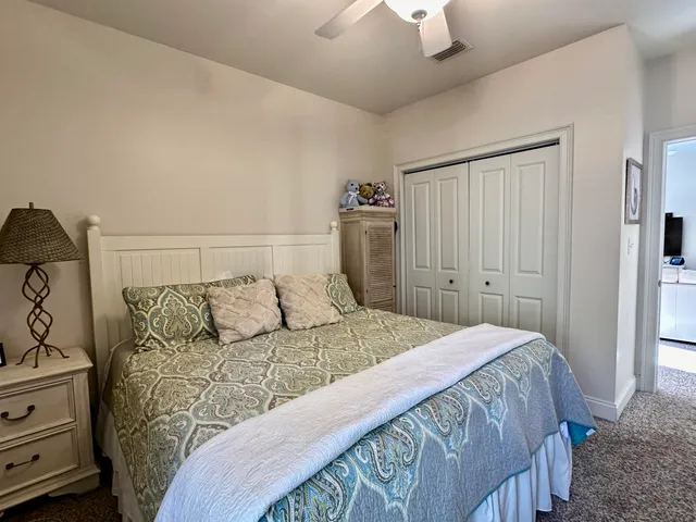 a bedroom with a bed and a lamp on the dresser