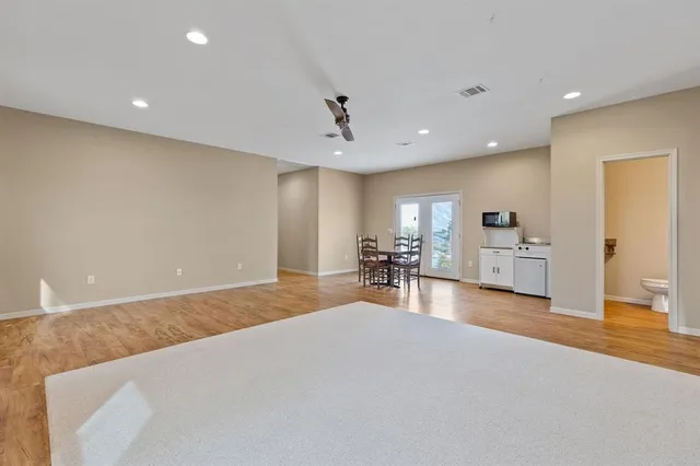 a large white kitchen with sink and a large window