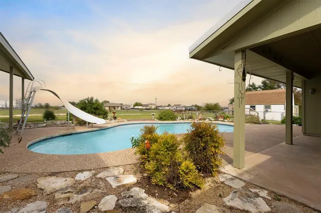 an empty room with windows and ceiling fan