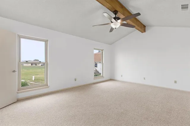 an empty room with closet and windows