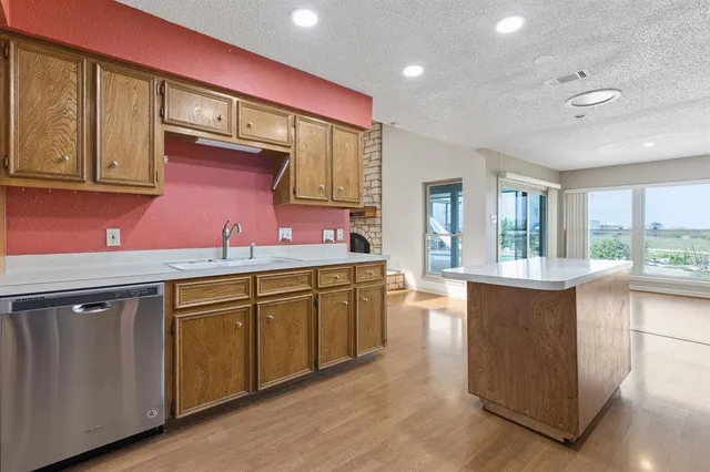 a kitchen with granite countertop cabinets stainless steel appliances and wooden floor