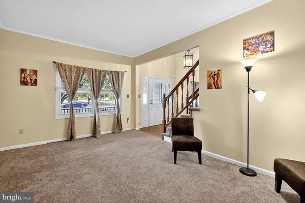 a view of an empty room with stairs and furniture