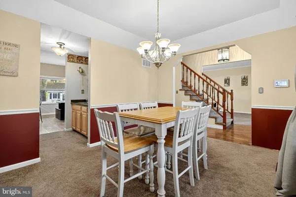 a view of a dining room with furniture and a chandelier