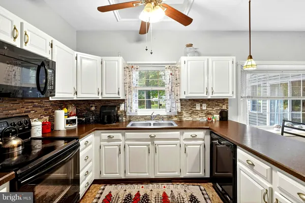 a kitchen with a sink stove top oven and microwave