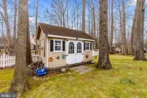 a view of a house with a yard patio and a tree
