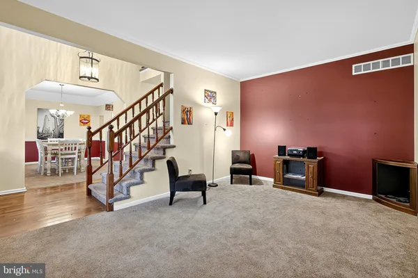 a view of a livingroom with wooden furniture and stairs