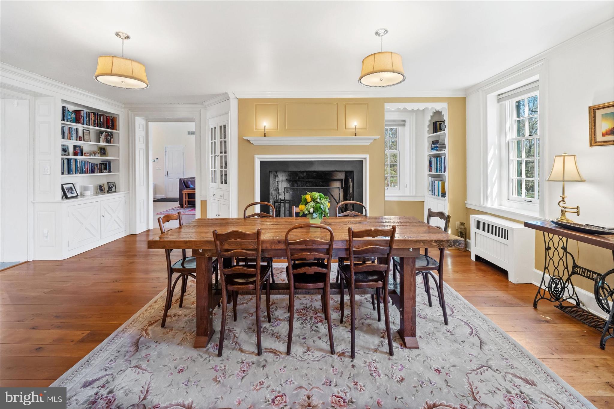 1439 Old Wilmington Road Hockessin, DE 19707 - Photo 13 of 57 a view of a dining room and livingroom with furniture wooden floor a rug a fireplace and a chandelier