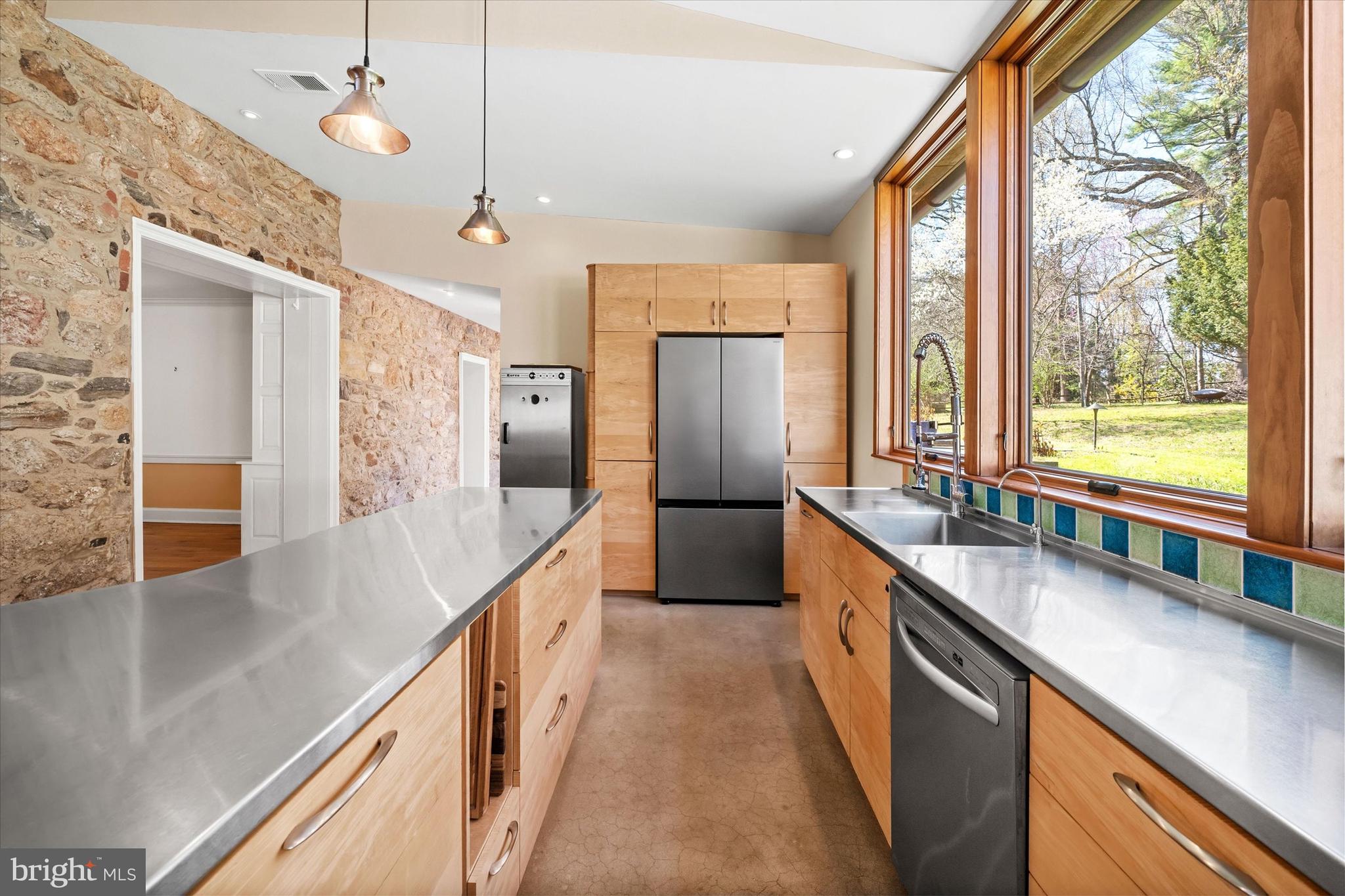 1439 Old Wilmington Road Hockessin, DE 19707 - Photo 18 of 57 a large kitchen with kitchen island a large window a sink and stainless steel appliances