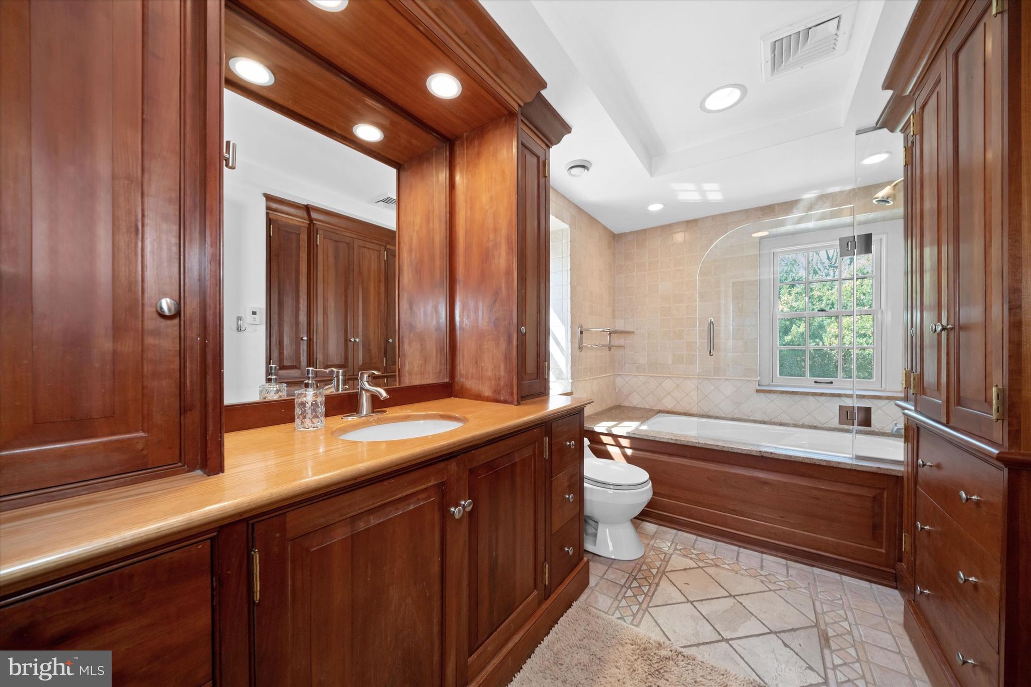 1439 Old Wilmington Road Hockessin, DE 19707 - Photo 36 of 57 a bathroom with a double vanity sink toilet mirror and bathtub
