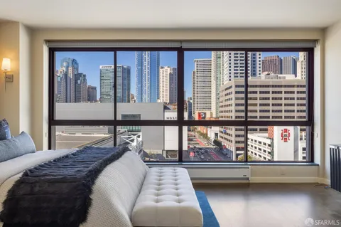 a bedroom with a large bed and windows