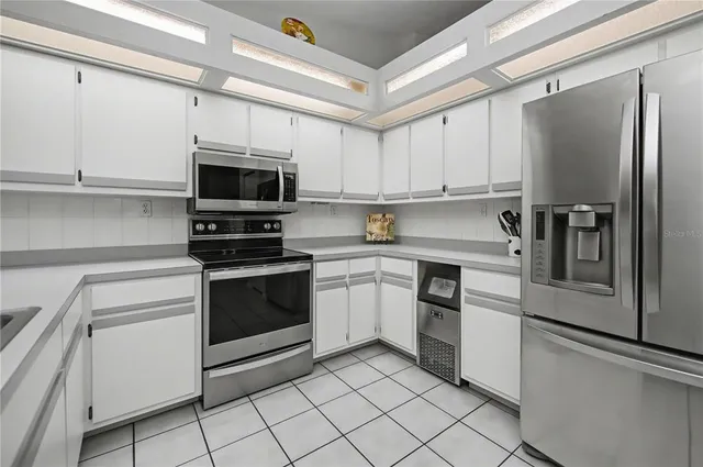 a living room with stainless steel appliances kitchen island granite countertop furniture and a large window