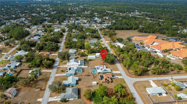 an aerial view of residential houses with outdoor space and trees