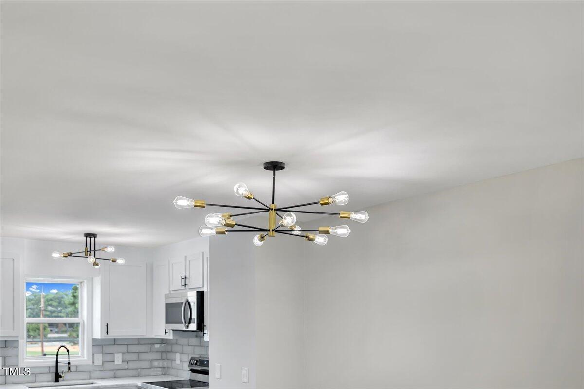 403 East Williams Street Angier, NC 27501 - Photo 14 of 38 a view of a kitchen with a sink and chandelier fan