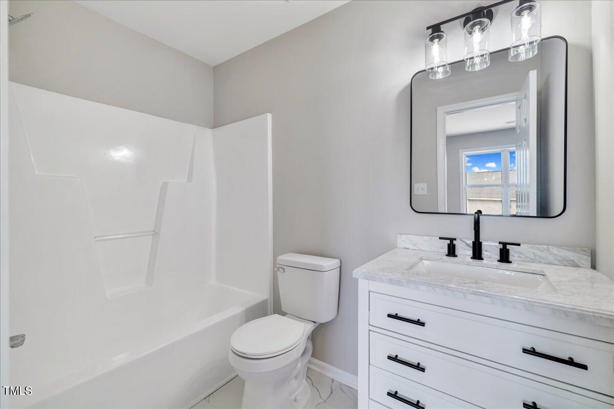 403 East Williams Street Angier, NC 27501 - Photo 20 of 38 a bathroom with a toilet sink and mirror