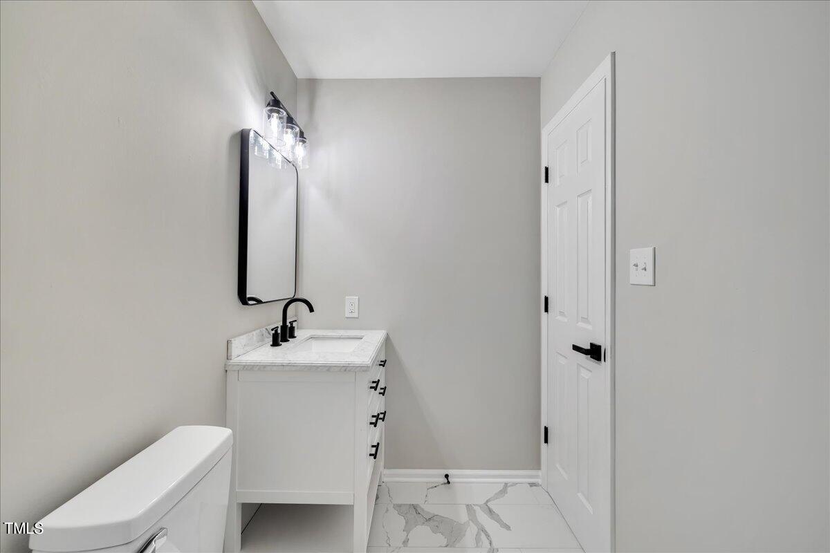 403 East Williams Street Angier, NC 27501 - Photo 21 of 38 a bathroom with a sink toilet and mirror