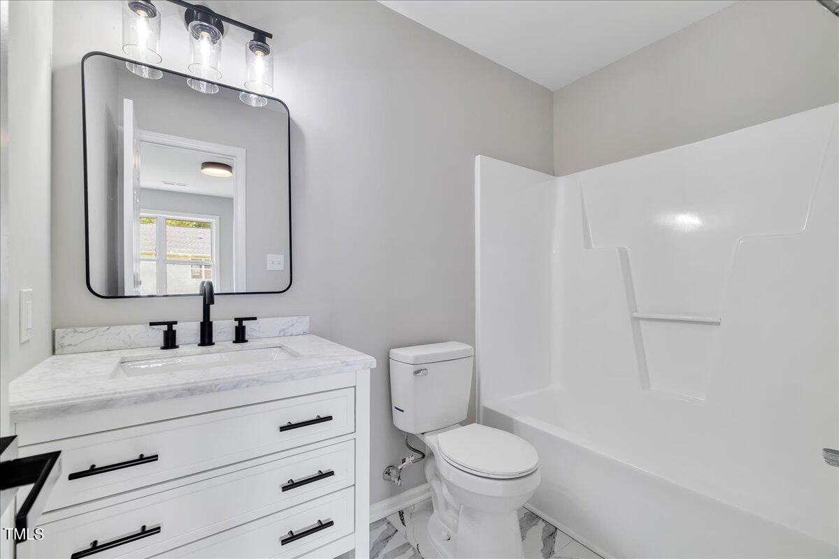403 East Williams Street Angier, NC 27501 - Photo 25 of 38 a bathroom with a toilet a sink a vanity and mirror