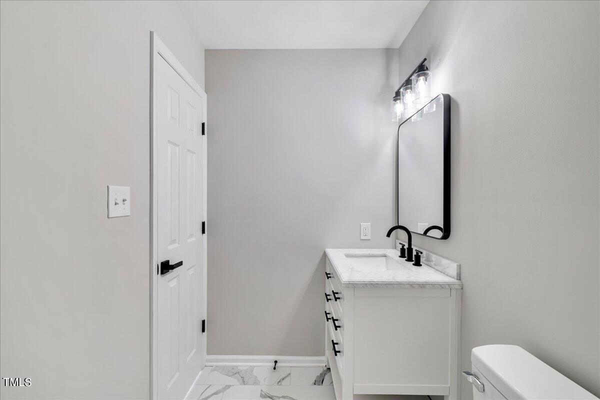 403 East Williams Street Angier, NC 27501 - Photo 26 of 38 a bathroom with a sink mirror and toilet