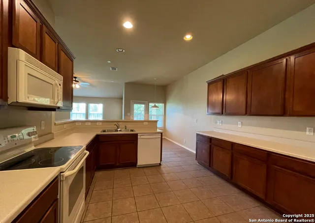 a kitchen with a sink and a stove top oven with wooden cabinets