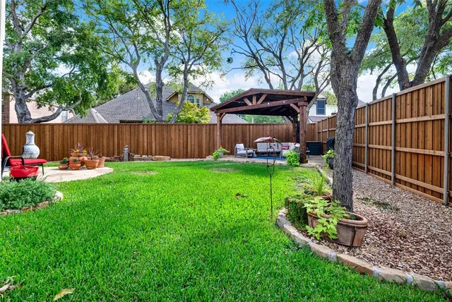 a view of a chair and table in backyard of the house