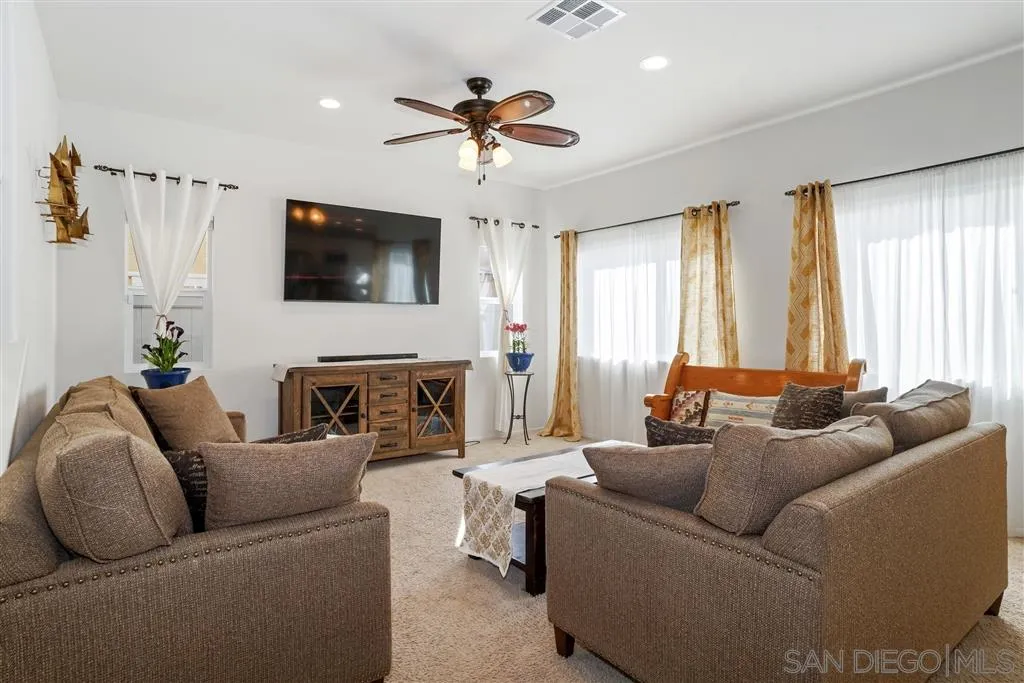 270 Oberlander Way Fallbrook, CA 92028 - Photo 8 of 23 a living room with furniture a fireplace and a flat screen tv