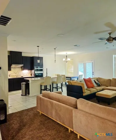 a living room with furniture and kitchen view