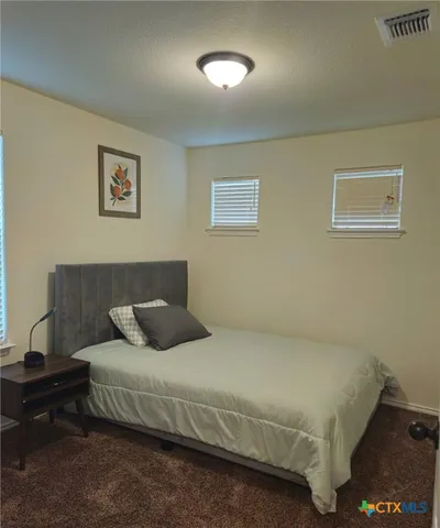 a bedroom with a bed and a night stand